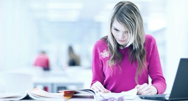 Eine Frau im Lesesaal einer Bibliothek. Foto: Shutterstock